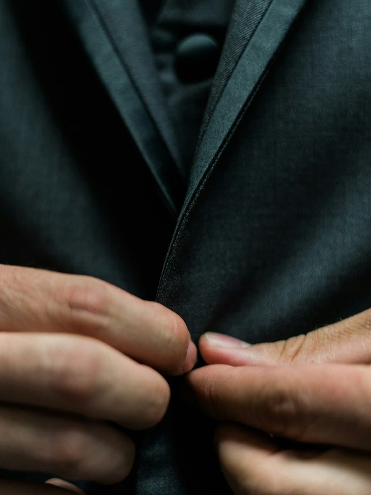 A three-piece suit, waistcoat buttoned, photographed in low light.